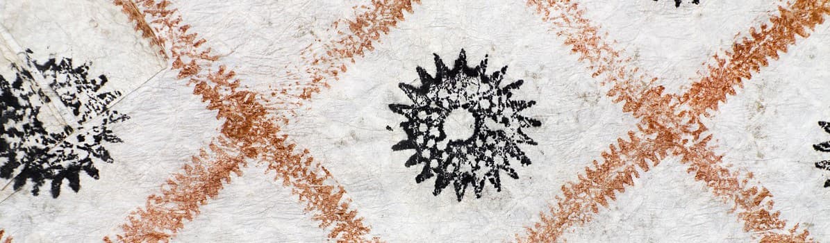 Black starburst pattern on a white fabric with brown diamond shapes.