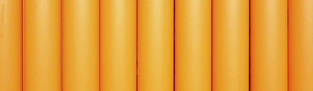 Abstract background of vertical gold stripes on a white surface.