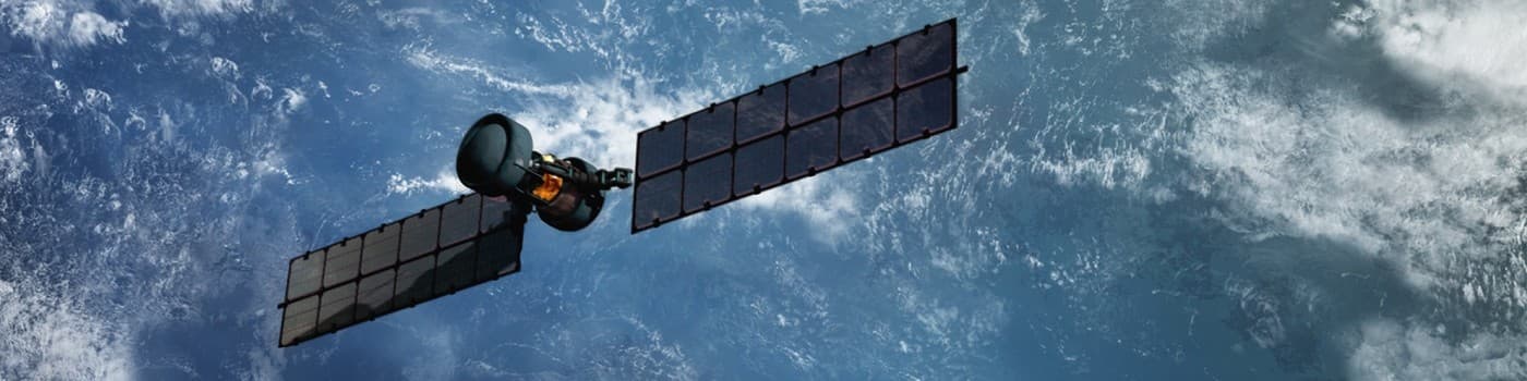 Satellite with solar panels against a blue sky with clouds.