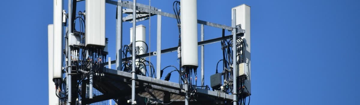 Cell tower against a clear blue sky.